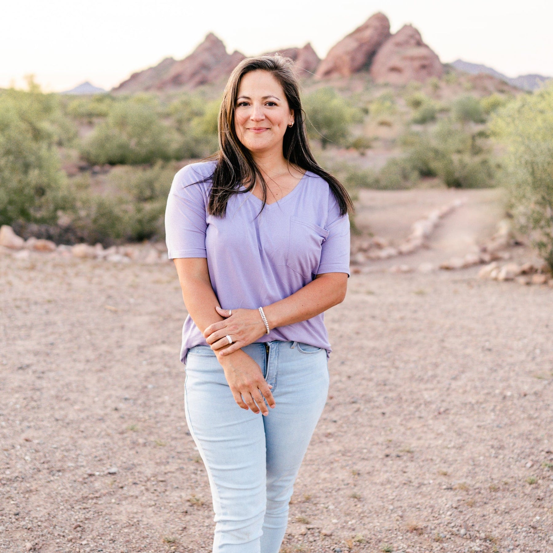 Female model standing in the desert wearing the Women’s Relaxed Fit V-Neck in Taro paired with light wash jeans